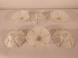 six clear glass dishes with lids on a white surface
