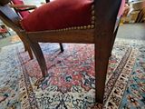 a red chair that is on a rug in a room