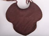 a brown piece of cloth with a white ball on it