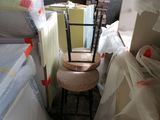 une chaise posée sur un tabouret au milieu d'une pièce