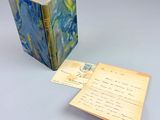 an open book sitting on top of a table next to a piece of paper