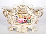 un vase blanc et doré orné de fleurs
