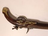a very old gun that is on display on the wall