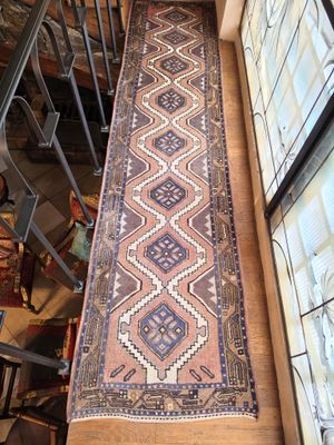 une photo montrant un long tapis posé sur un parquet, près d'une fenêtre