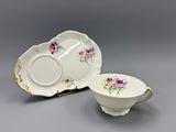 two pieces of porcelain dishes with flowers on them on a gray surface