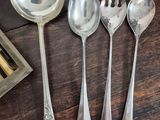 several silver spoons and spoon spoons on a wooden table