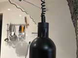 a black lamp that is on a counter in a kitchen