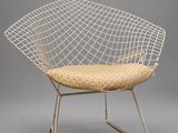 une chaise « Diamond » blanche avec une assise en osier et des pieds en métal