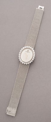 a close up of a wrist watch with a chain around it