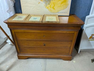 une photo d'une commode sur laquelle sont posées des photos