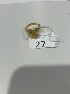 une bague en or posée sur une table blanche