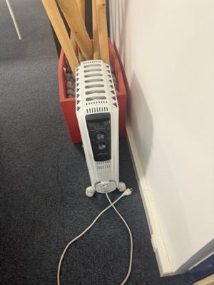 an image of a room with a heater and a basket of wood sticks