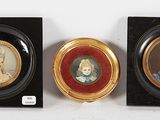 three miniature portraits of women are on display in a black frame