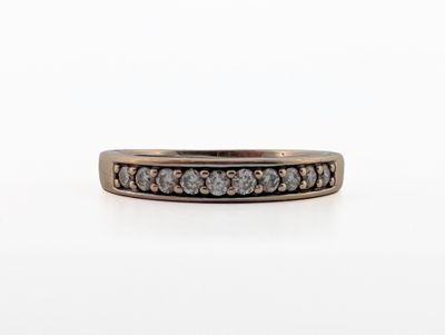 a close up of a ring with a row of diamonds on it