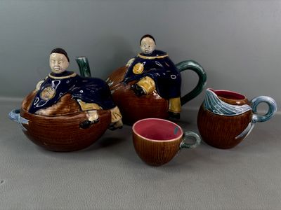 trois figurines en céramique représentant des personnes assises sur une théière