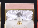 three boxes of perfumes are lined up on a black surface