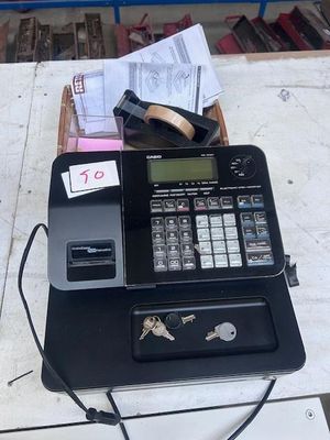 a cash register sitting on top of a table next to a bunch of keys