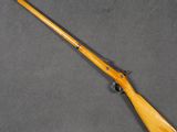 an old rifle with a wooden handle on a gray surface