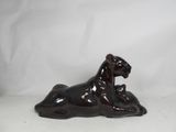 brown ceramic dog figurine laying down on a white background