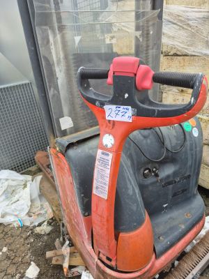 une photo d'un scooter rouge et noir garé devant un immeuble