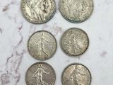 six types différents de pièces d'argent posées sur une surface en marbre