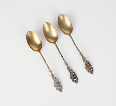 un ensemble de quatre cuillères en argent posées sur une surface blanche