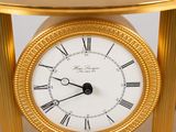 a gold clock with roman numerals on top of it