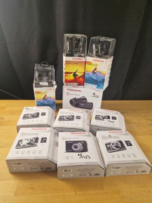 des boîtes d'appareils photo posées sur une table en bois, à côté d'un rideau noir
