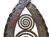 a metal sculpture with spiral designs on it ' s sides