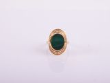 a gold ring with a green stone in the center