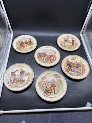 six plates that are in a box on the floor