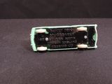 a close up of a small green battery on a black surface