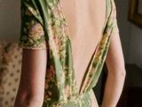 a woman in a green dress standing in a living room
