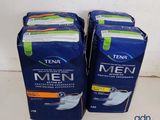 two packs of tena men sanitary pads sitting on a counter