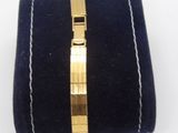 bracelet with a gold plated clasp on a blue velvet case