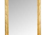 un miroir encadré d'or sur un mur blanc avec un fond blanc
