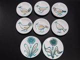 six assiettes ornées d'oiseaux, posées sur une table
