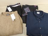 three pairs of men ' s sweaters and pants sitting on a couch