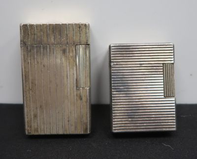 two silver lighters sitting next to each other on top of a table