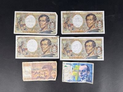 six billets différents, de couleurs et de motifs variés, sur un fond noir