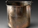 une vieille casserole en argent avec une poignée, sur fond noir