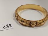 une photo d'une bague en or posée sur une table blanche
