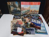 plusieurs magazines posés sur une table, avec une voiture en arrière-plan
