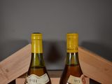 two bottles of wine sitting on a table next to each other