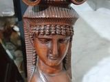 une statue en bois d'une femme avec un chapeau sur la tête