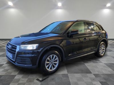 un SUV Audi noir garé sur un sol en carrelage à damier