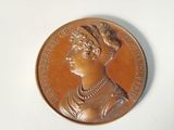 une médaille de bronze sur laquelle est représenté le visage d'une femme