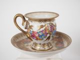 a small cup and saucer on a stand