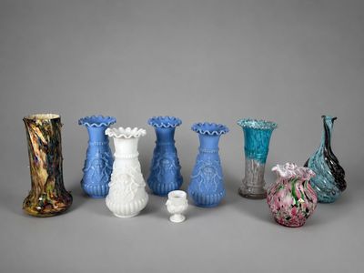 cinq vases différents posés les uns à côté des autres sur une surface grise