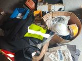 une boîte remplie de vêtements et d'autres objets posée par terre